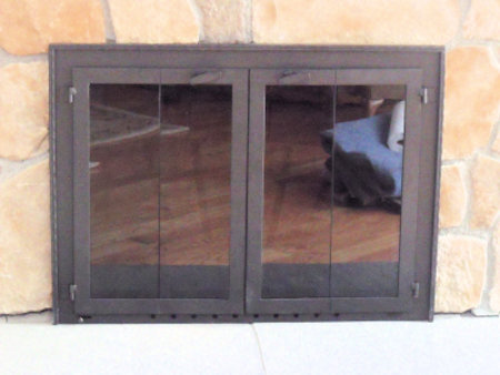 Buzzards Bay (Molding on surround)  All black frame with half inch hammer and groove molding,  vice bi fold doors, smoked glass. Comes with slide mesh spark screen.  (Installed on stone)